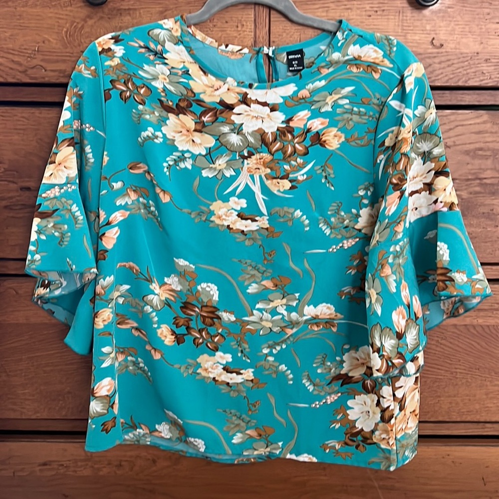 Turquoise floral print short sleeved blouse.